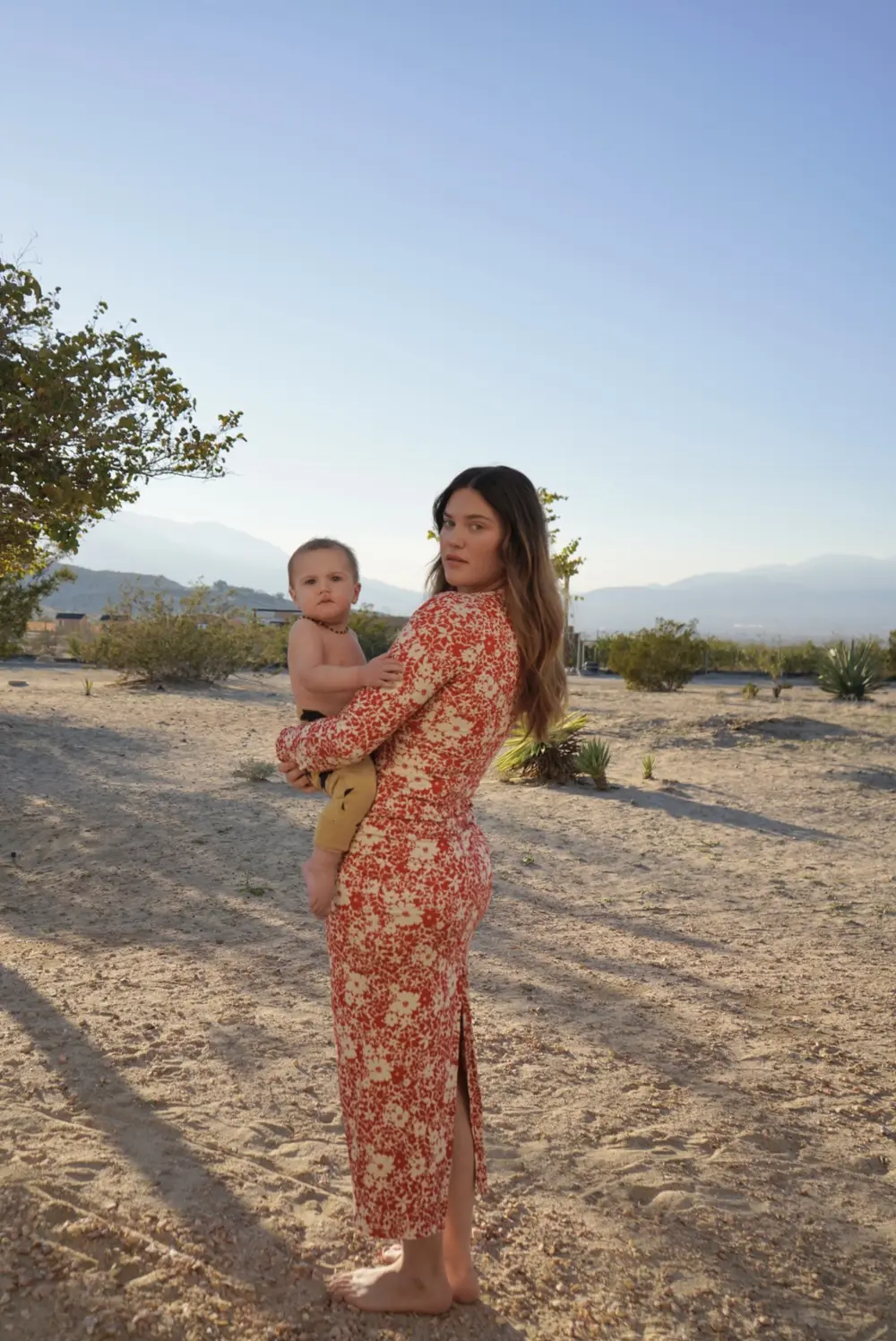 Ali Tate Cutler, founder of Unfckwithable, holding her son in the desert